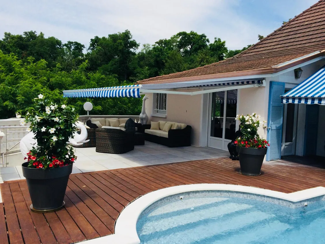 Store banne déployé sur une terrasse avec piscine